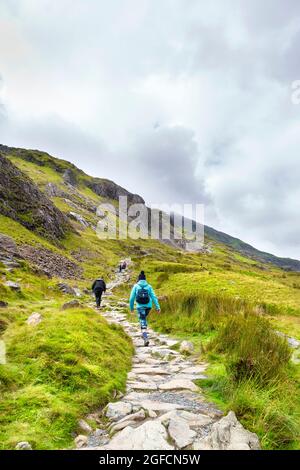 Wanderer wandern auf einem Pfad entlang des PYG Track in Snowdon, Snowdonia National Park, Wales, Großbritannien Stockfoto