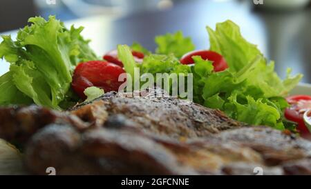 Gegrilltes Steak Mit Tomaten Und Salat, Seitenansicht Nahaufnahme Foto Stockfoto