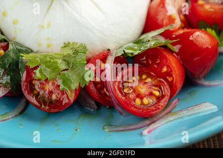 Burrata Käsesalat mit Kartoffeln auf einem blauen Teller Stockfoto