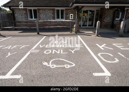 Parkplatz markiert EV Fahrzeug nur in einem Dorf Halle Parkplatz, Großbritannien Stockfoto