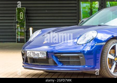 Porsche blaues Auto nahe dem Laden mit High Power Ladetechnologie. Russland, Sankt Petersburg, 27. Mai 2021 Stockfoto