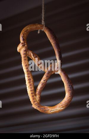 Große leckere frische Brezel, Crousan mit Sesam, der an einem Faden hängt Stockfoto