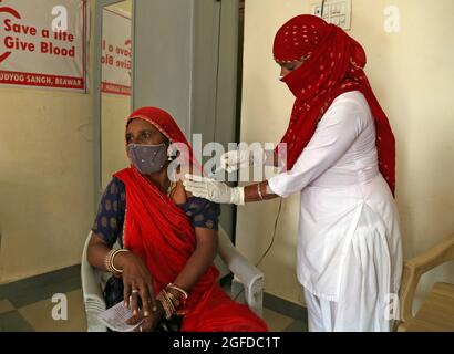 Beawar, Rajasthan, Indien, 25. August 2021: Gesundheitshelfer verabreichen einem Begünstigten eine Dosis COVID-19-Impfstoff während einer speziellen eintägigen Impfkampagne für Arbeiter im RICCO-Industriegebiet in Beawar. Indien hat ​​over Millionen US- 594 verabreicht, was mehr als 325 Millionen Menschen mit mindestens einer Dosis COVID-19-Impfstoff abdeckt. Kredit: Sumit-Samarwat/Alamy Live Nachrichten Stockfoto