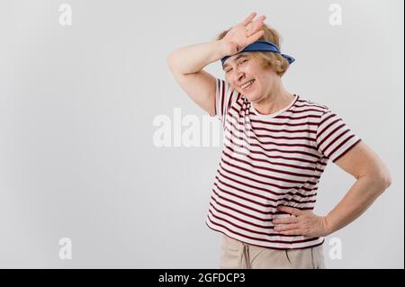 Eine ältere Frau wischt sich nach dem Sport den Schweiß von der Stirn. Stockfoto