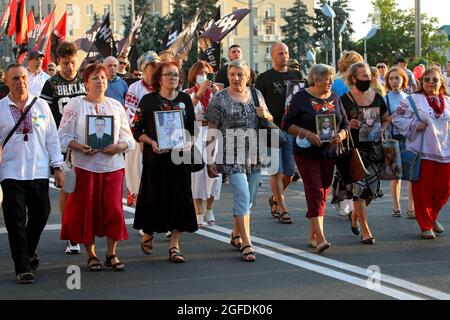 CHARKIW, UKRAINE - 24. AUGUST 2021 - Frauen tragen die Fotos der umgekommen Soldaten während des Marsches der Verteidiger, die zur Feier des 30 Stockfoto