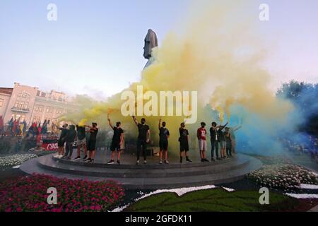 CHARKIW, UKRAINE - 24. AUGUST 2021 - Männer halten blaue und gelbe Rauchbomben am Taras Schewtschenko-Denkmal während des Marsches der Verteidiger, der in der Gedenkstätte stattfand Stockfoto