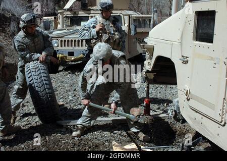 Soldaten des Scout Platoon, Headquarters and Headquarters Company, 2/87 Infantry, wechseln während der Operation Catamount Fury, einer Bataillongrößenmission, die im März 29 in der Provinz Paktika in Afghanistan stattfand, einen Platten Reifen, um die Bewegung der Taliban innerhalb Paktika zu begrenzen. Stockfoto