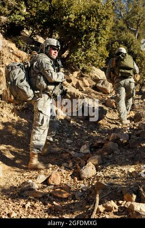 US Army Staff Sgt. Dennis Speek, Teamleiter der 707. Explosiven Ordnance-Entsorgung, Fort Lewis, Washington, patrouilliert auf einem Berg, um das „Taliban Hotel“ zu zerstören, ein Schutzhaus, das von aufständischen Kämpfern genutzt wird, die Afghanistan in der Nähe des Kampfvorstands Spera, Provinz Khost, infiltrieren, Dez. 18. Das EOD-Team hat sich mit Soldaten der 1-40. Kavallerie (Airborne), Fort Richardson, Alaska, und den afghanischen nationalen Sicherheitskräften zusammengetan, um die Sicherheitskräfte zu nivallieren. Stockfoto