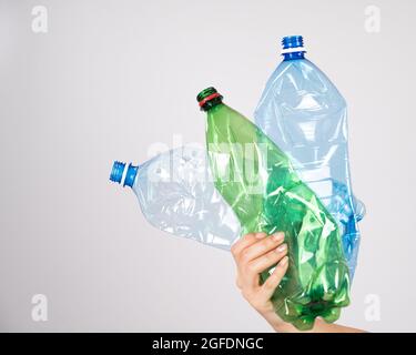 Nahaufnahme einer weiblichen Hand, die eine Plastikflasche auf weißem Hintergrund hält. Stockfoto