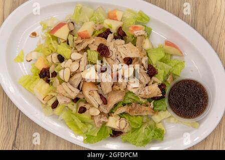 Blick von oben auf herzhaften Salat, der hoch auf den Teller mit Rosinen gefüllt und gestapelt wurde. Stockfoto