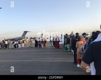Kabul, Afghanistan. August 2021. Menschen stehen Schlange, um an Bord eines deutschen Militärflugzeugs zu gehen und Kabul am Flughafen Kabul, Afghanistan, zu verlassen, 24. August 2021. Quelle: Xinhua/Alamy Live News Stockfoto