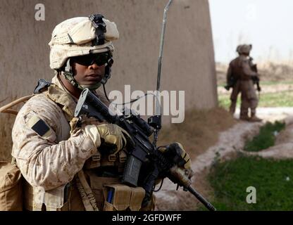 Erstes Sgt. Fredrick A. Smith, erster Sergeant der Charlie Company, 1. Bataillon, 3. Marine-Regiment, unterhält während des ersten Treffens mit Dorfältesten aus dem Five Points-Gebiet am 14. Februar die Sicherheit. Marines waren zuvor aufgrund von Engagements mit Taliban-Kämpfern während ihrer Patrouillen nicht in der Lage gewesen, sich mit lokalen Führern zu treffen. Smith, 39, kommt aus Kingsland, Georgia Stockfoto