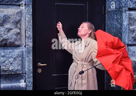 Eine Erwachsene Frau klopft alarmierend an die Tür eines alten Hauses Stockfoto