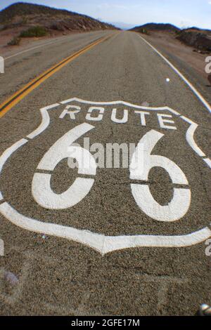 Paint on the Road kündigt an, dass es die Route 66 ist, die sich bis zum Horizont erstreckt Stockfoto