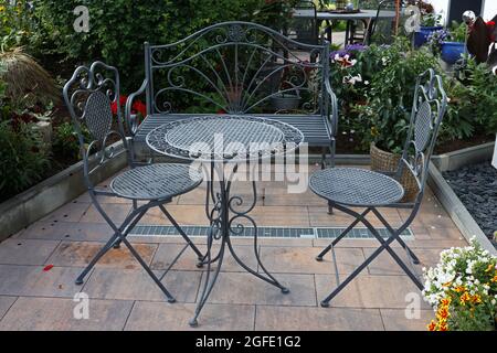 Lockige Metallmöbel im Garten in der Nähe des Hauses. Stockfoto