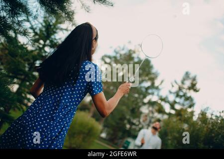 Junges erwachsenes Paar spielt Badminton im Park. Stockfoto