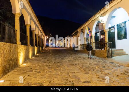 VILLA DE LEYVA, KOLUMBIEN - 21. SEPTEMBER 2015: Stimmungsvolle Abendansicht einer gepflasterten Straße in der Kolonialstadt Villa de Leyva, Kolumbien. Stockfoto