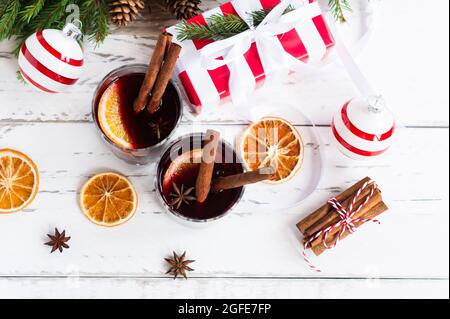 Zwei Gläser Glühwein mit Gewürzen und trockenen Orangen. Festliche Grußkarte für weihnachtsferien, Draufsicht. Stockfoto