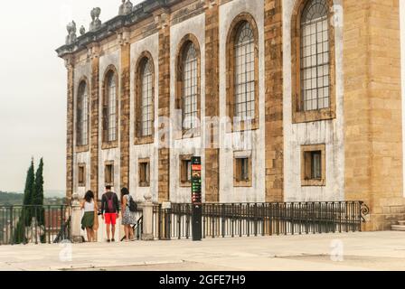 Touristen in der Nähe des Eingangs der Joanina-Bibliothek am Platz der Universität von Coimbra, die die Treppe hinunter gehen, bewölktes Wetter - Portugal Stockfoto