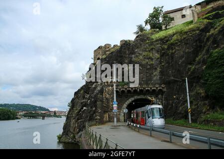 Der alte und historische Vyšehrad-Tunnel in Prag in der Tschechischen Republik mit einer modernen Straßenbahn. Wird auch von den Autos verwendet. Tor zum historischen Zentrum der Stadt. Stockfoto