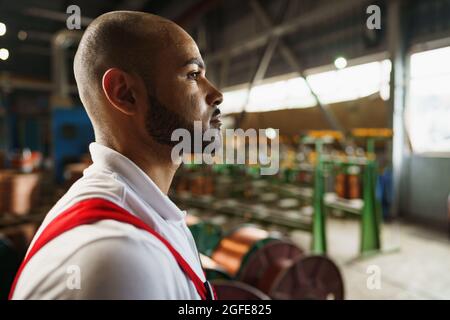 Profilfoto des jungen afroamerikanischen Handwerkers, der in einer Fabrik arbeitet Stockfoto