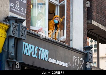 London, Großbritannien. 25. August 2021. Die Menschen beobachten, wie Klimaaktivisten vom Aussterbungsaufstand in Soho protestieren. Die Veranstaltung ist Teil des Protestes ‘Unmögliche Rebellion’, um „die Ursache der Klima- und Umweltkrise anzuvisieren“ und dauert zwei Wochen, bis die Regierung zustimmt, alle Investitionen in neue fossile Brennstoffe zu stoppen. Kredit: Stephen Chung / Alamy Live Nachrichten Stockfoto
