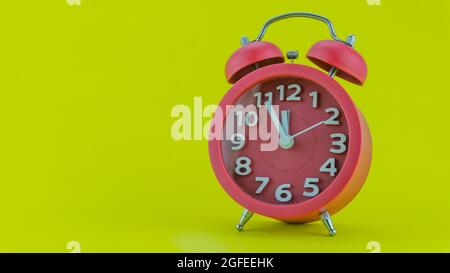 Roter Wecker auf gelbem Hintergrund vor zwölf Uhr am Silvesterabend des Gesichts des schönen Weckers zeigt Mitternacht liebenswert Silvester cel Stockfoto