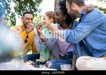 Fröhliche junge Freunde, die sich im Park die Fäuste anschmiegen Stockfoto