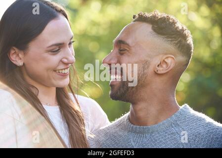 Nahaufnahme eines lächelnden jungen Paares, das sich im öffentlichen Park ansieht Stockfoto