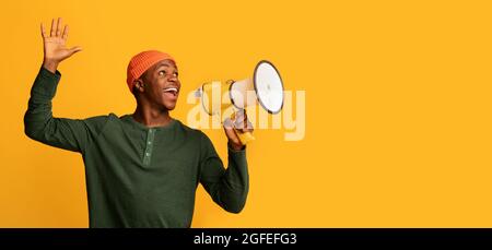 Portrait Of Joyful Black Guy With Megaphone In Hands Making Announcement, Excited African Man Holding Lautsprecher, Nachrichten Teilen Oder Interessantes Angebot Stockfoto