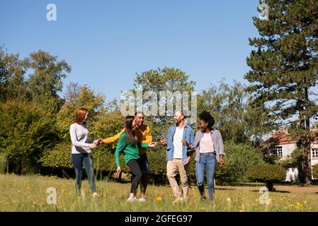 Glückliche junge Freunde, die Spaß im öffentlichen Park haben Stockfoto