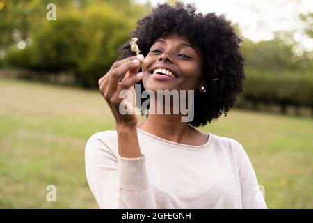 Junge Frau bläst Blume Löwenzahn Stockfoto