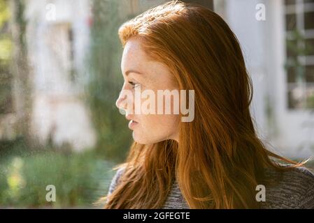 Seriöse junge Frau, die im öffentlichen Park wegschaut Stockfoto