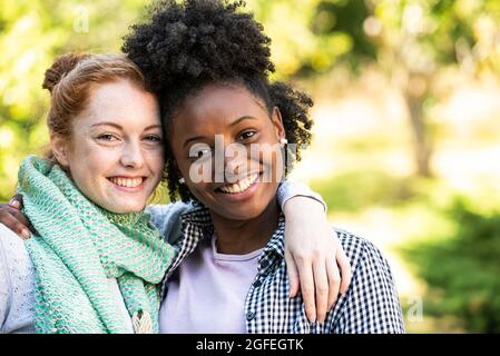 Porträt lächelnder junger Frauen mit den Armen Stockfoto