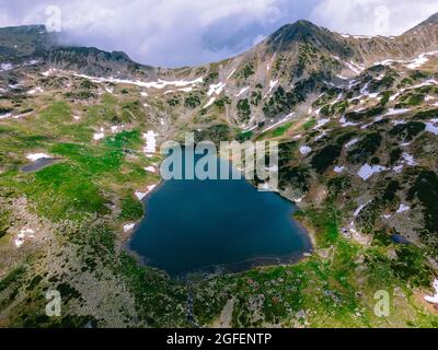 Schöner Blick auf einen Gletschersee in den Bergen unter wolkenbewölkter Luft. Blick auf den Bucura-See in Retezat-Bergen in Rumänien. Stockfoto