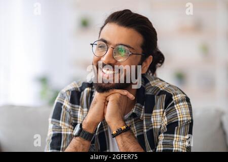 Gutaussehender, tausendjähriger arabischer Mann, der zu Hause ruht Stockfoto