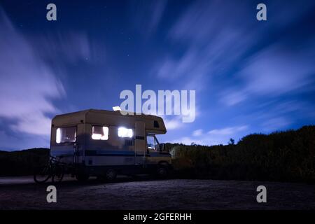 Van Life-Konzept. Lange Exposition von Freizeitfahrzeug, auch Camper genannt, in der Nacht unter den Sternen mit klarem Himmel und Blick auf die Milchstraße in t geparkt Stockfoto