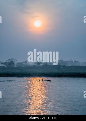 Iquitos, Brasilien - Mai, 2016: Kleines Boot mit Einheimischen auf dem Amazonas während Sonnenaufgang, Amazonien. Lateinamerika. Stockfoto