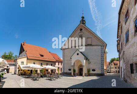 Ein Bild der St. Jakobs Kirche und ihres Platzes, in Škofja Loka. Stockfoto