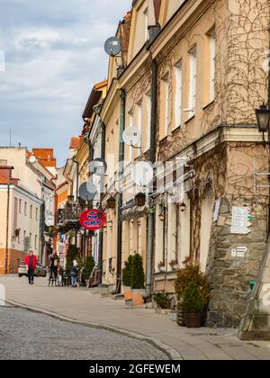 Sandomierz, Polen - 17. Februar 2020: Historische Mietshäuser und das prächtige Opatowska-Tor von Sandomierz, eines der ältesten und historisch Stockfoto