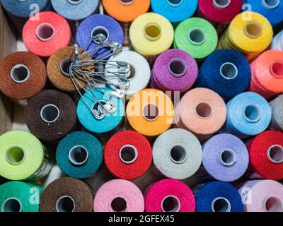 Viel Nähen von farbigem Faden. Gewinderollen. Bunte Fäden im Karton. Struktur des Nähzubehörs Stockfoto