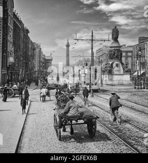 Ein Foto aus dem frühen 20. Jahrhundert von Pferdefahrzeugen in der Sackville Street, später in O'Connell Street in Dublin City, Irland, umbenannt. Die Statue ist die von Daniel O'Connell und darüber hinaus ist Nelson's Column und die Fassade des General Post Office (links) Stockfoto