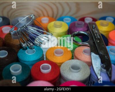 Viel Nähen von farbigem Faden. Gewinderollen. Bunte Fäden im Karton. Struktur des Nähzubehörs Stockfoto