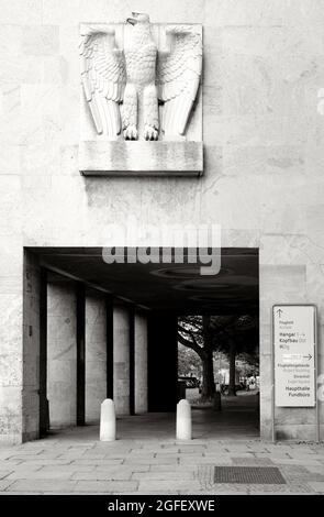 Berlin, 27. Juli 2021, Nazi-Adler am Flughafen Tempelhof und ein Schild mit Hinweisen auf den Kopfbau, die Haupthalle und die Verlorene Stockfoto