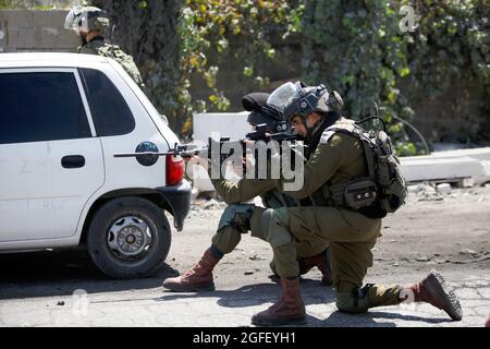 Nablus, Palästina. August 2021. Israelische Soldaten feuern während der Demonstration Tränengas auf palästinensische Demonstranten. Palästinenser protestieren gegen den Bau einer neuen Straße für israelische Siedler und fordern auch die Entfernung des israelischen Außenpostens Eviatar in der Nähe von Beita, südlich von Nablus im Westjordanland. Kredit: SOPA Images Limited/Alamy Live Nachrichten Stockfoto