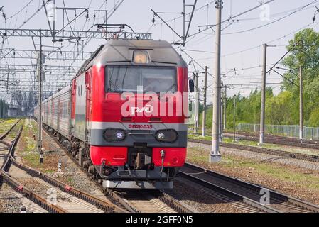 LENINGRAD, RUSSLAND - 24. MAI 2021: Russische elektrische Personenzuglokomotive EP2K-035 mit Nahaufnahme des Personenzugs an einem sonnigen Maitag Stockfoto