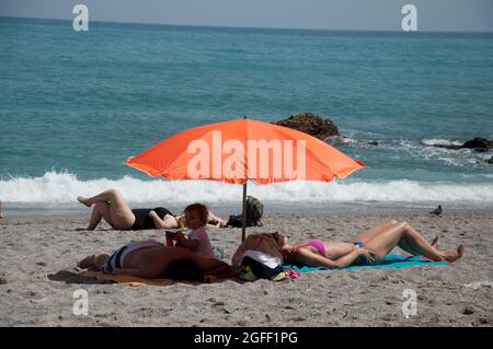 Sonnenbaden in einer kleinen Bucht im Mittelmeer, Nerja, Costa del Sol, Provinz Malaga, Andalusien, Spanien Stockfoto