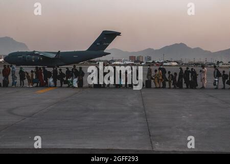 Evakuierte warten während einer Evakuierung auf dem Hamid Karzai International Airport, Kabul, Afghanistan, am 23. August auf den Einsteigen in eine Boeing C-17 Globemaster III. US-Dienstmitglieder unterstützen das Außenministerium bei einer nicht-kämpferischen Evakuierungsoperation (NEO) in Afghanistan. (USA Marine Corps Foto von Sgt. Isaiah Campbell) Stockfoto