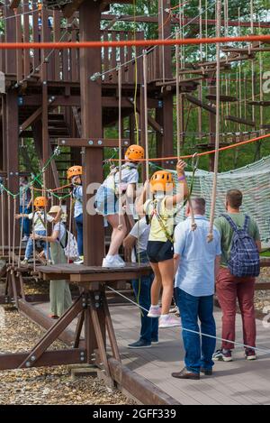 SANKT PETERSBURG, RUSSLAND - 11. AUGUST 2021: Kinder mit ihren Eltern in der Seilstadt. Attraktion im Park 'Insel der Forts', Kronstad Stockfoto