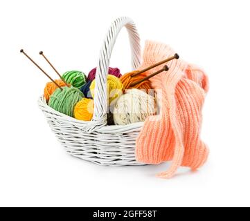 Kugeln aus Wollfäden zum Stricken im Korbkorb isoliert auf weißem Hintergrund. Stockfoto